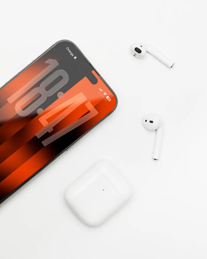 iPhone и наушники AirPods на белом столе