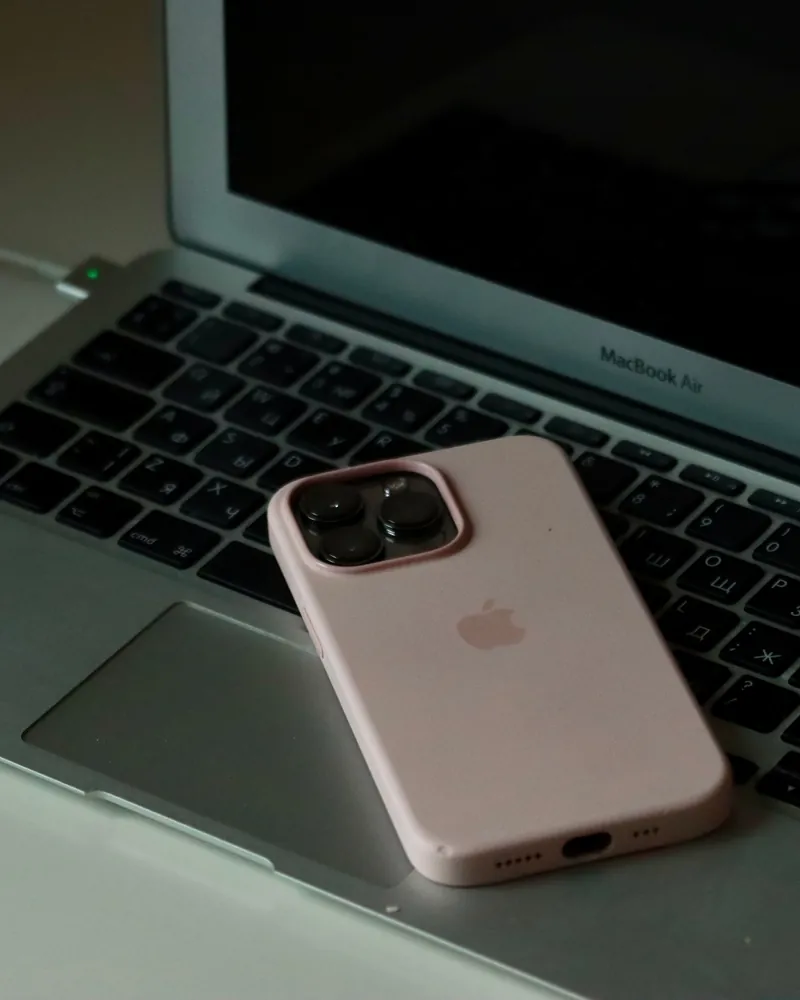 iPhone в розовом чехле на ноутбуке