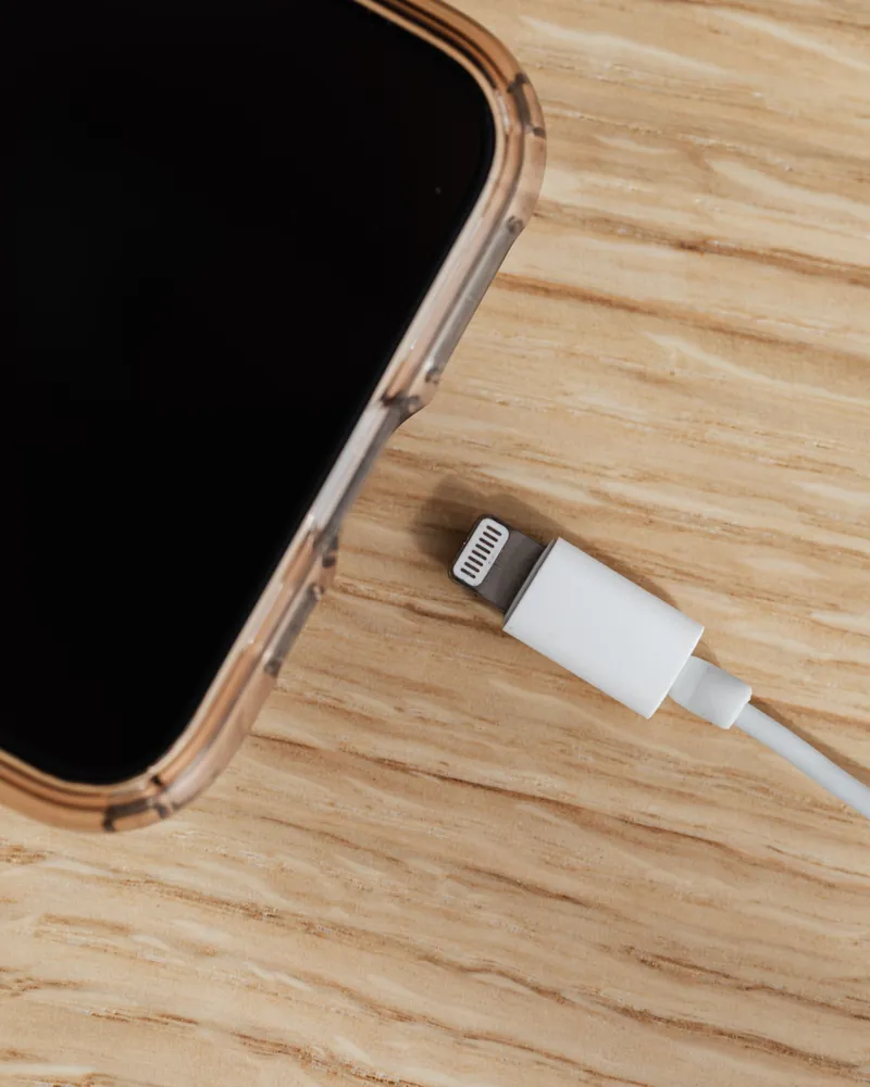 Зарядный кабель рядом с iPhone в прозрачном чехле